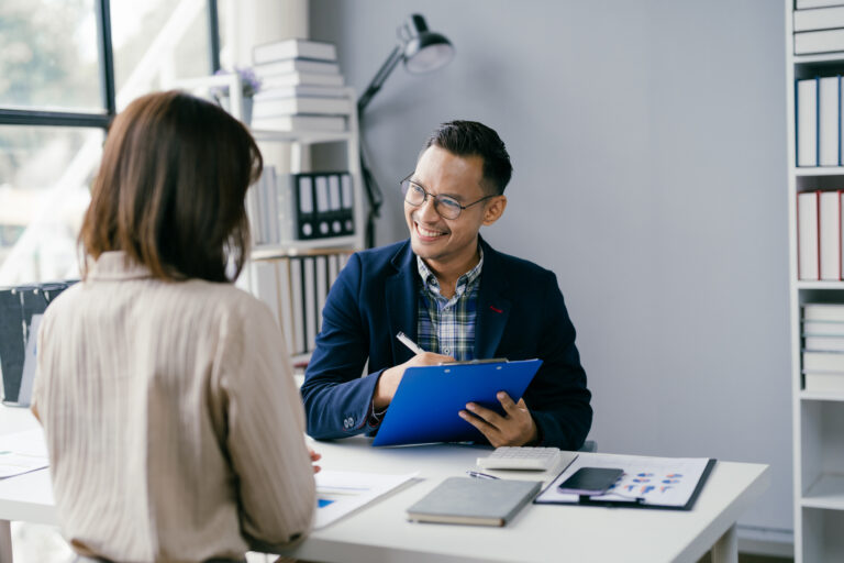 Business Meeting in Modern Office with Smiling Professional Holding Clipboard and Discussing Documents