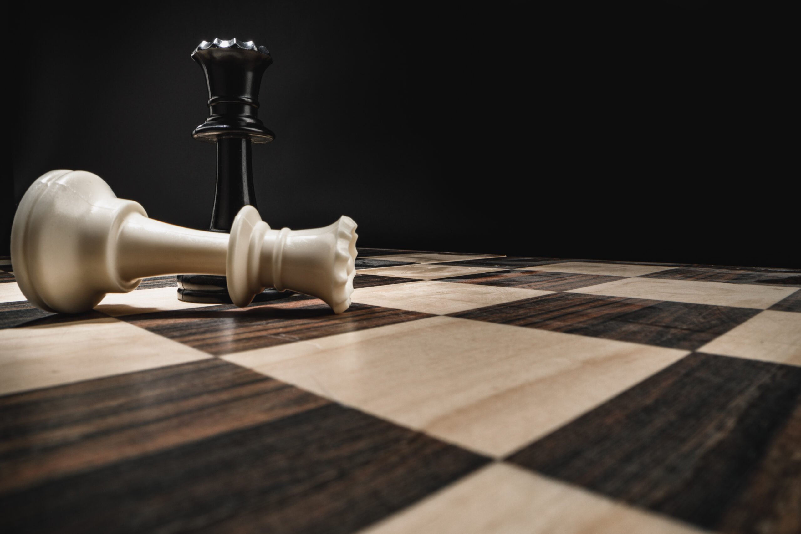 Pièces d’échecs sur un échiquier symbolisant la stratégie et la compétition.