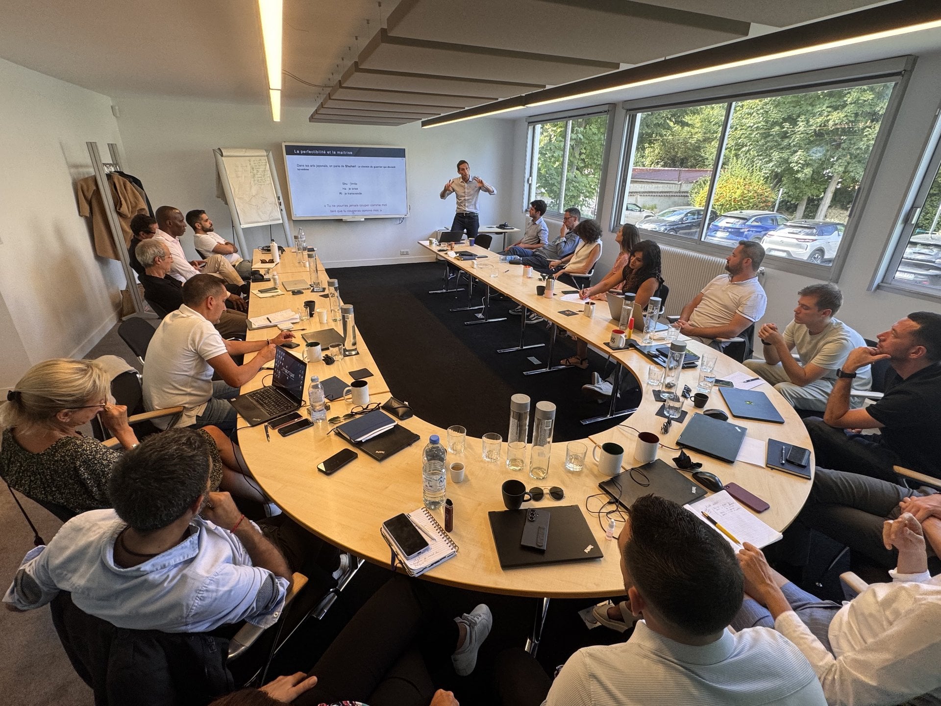 Formation manager IA Moortgat : session en salle avec un formateur animant un groupe de managers autour d une table
