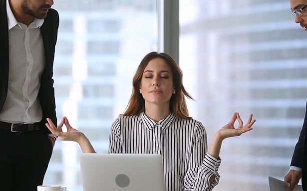 Une collaboratrice pratique un exercice de respiration au bureau